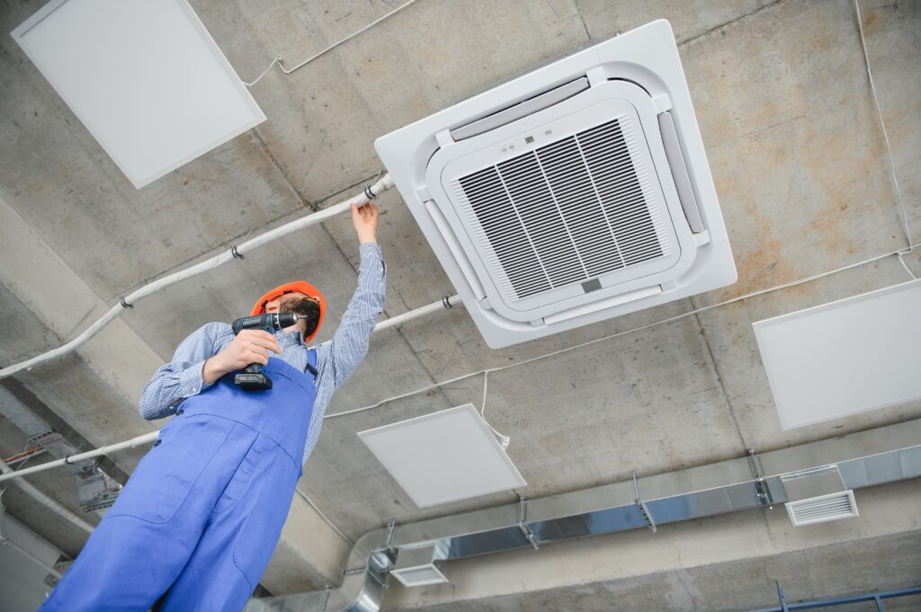 Happy Male Technician Repairing Air Conditioner