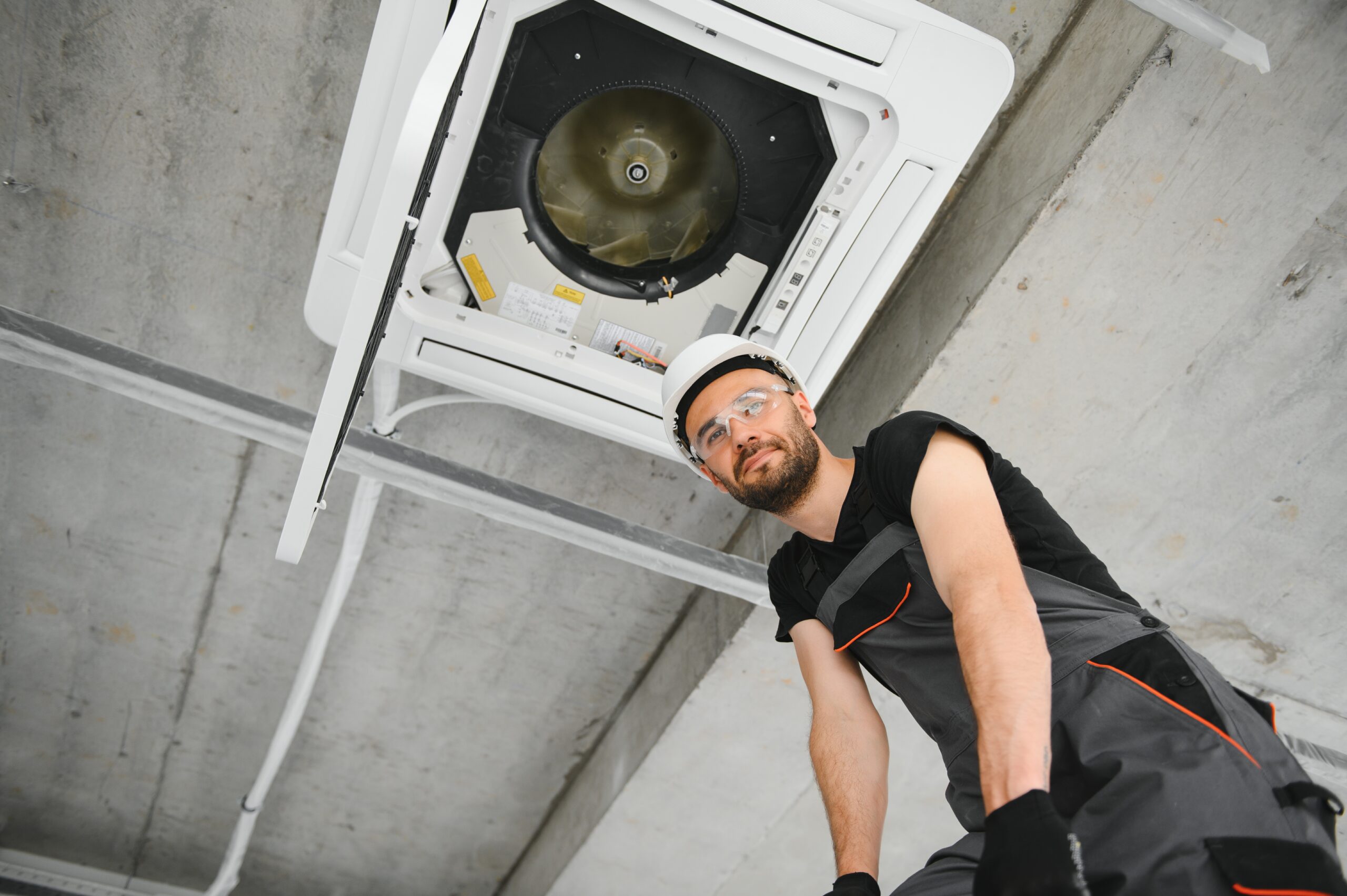 technician cleans air conditioner system in a modern apartment.